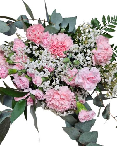 A bouquet wrap of pink carnations and mini carnations along with babies breath and baby blue eucalyptus greens